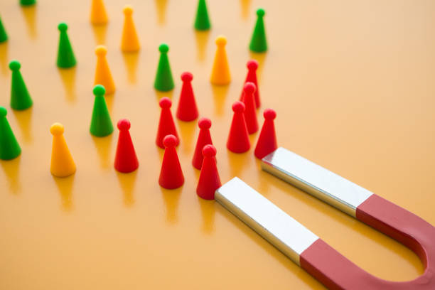 istock Horseshoe magnet attract red people from crowd on yellow background. 1617839630
