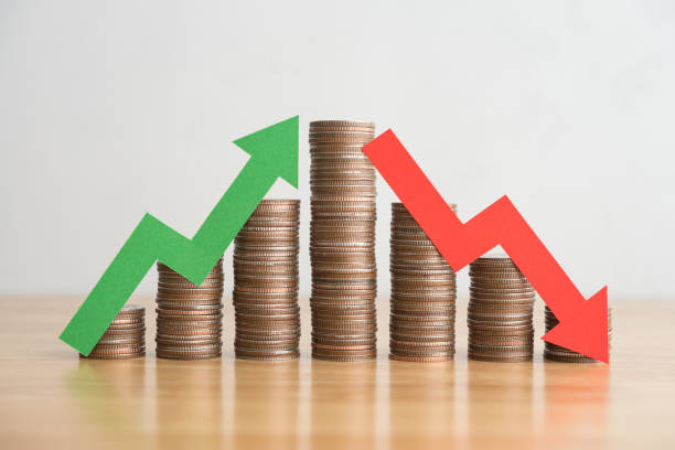 istock Stack coins and arrow red green graph chart volatility up and down on wooden table background. 1617848593