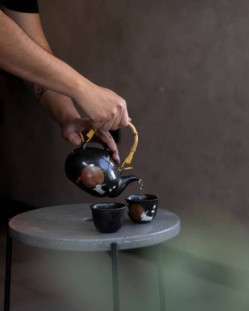 istock serving tea with a special ceramic teapot over two small tea cups 1617863877