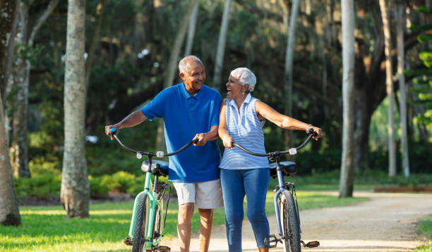 istock Senior African American couple walk with bikes, laughing 1617864390