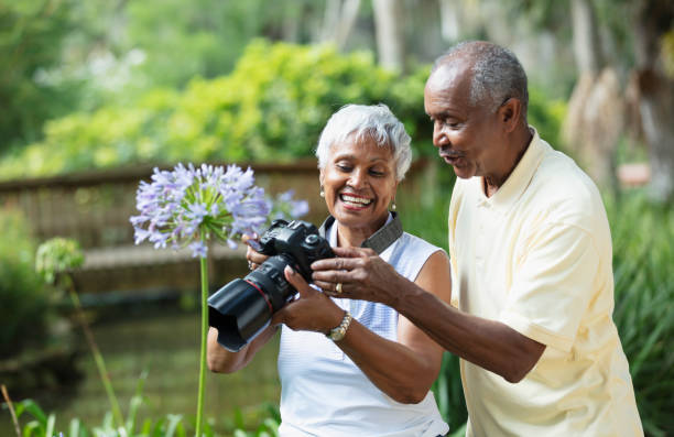 Senior African-American couple taking photos in park