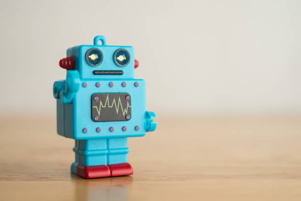 istock Blue cute retro AI robot toy on wooden background copy space. 1617873041