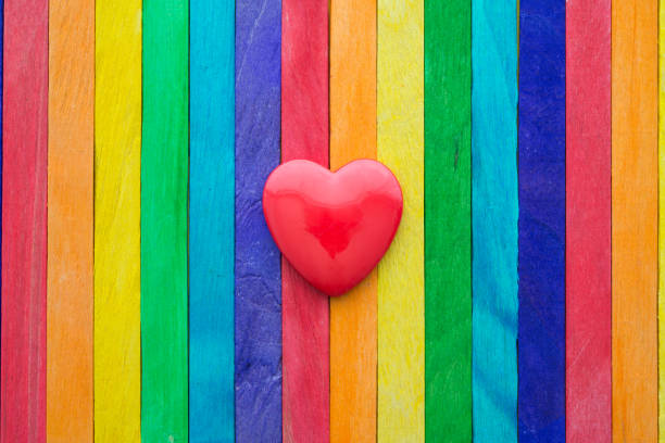 istock Red hearts on colored painted wood like a LGBT pride flag background with copy space. 1617917862