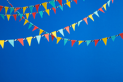 Colorful bunting flags paper on blue background with copy space. Concept of celebration, festival, party, happy birthday, design decoration.