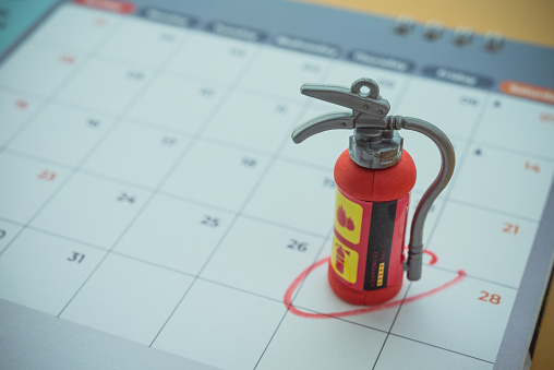Fire extinguisher on calendar background with copy space. Concept of fire extinguisher education and training program appointment schedule in organization, office company, factory, school, etc.