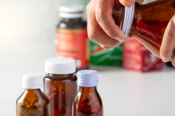 istock Two hands opening a medicine bottle 1617942640