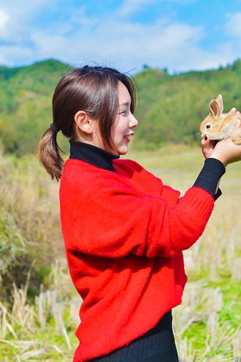 A lady is playing outdoors with her little pet