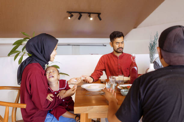 istock Small Family Praying before Having Meals at Dinner Table 1617958533