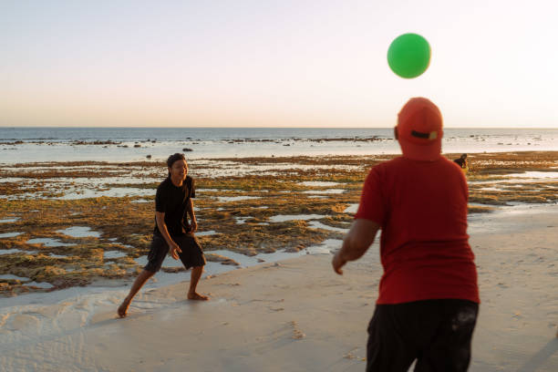 Indonesian family reunion in a beautiful beach house having BBQ and playing at the beach