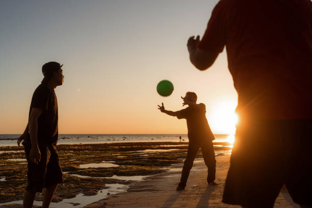 istock Indonesian Playing Catch Ball at the Beach during Sunset 1617976478