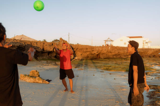 istock Indonesian Playing Catch Ball at the Beach during Sunset 1617978056