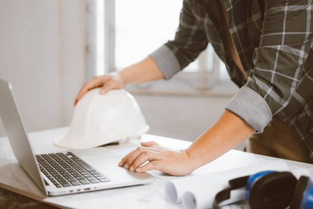 istock Architecture engineer working with blueprints and laptop in office. Inspection in workplace for architectural plan. Construction project. Adviser construction site engineer. 1618014730