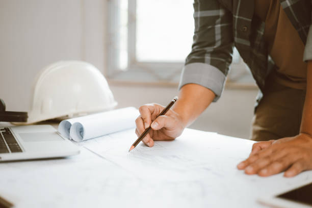 istock Architecture engineer working with blueprints and laptop in office. Inspection in workplace for architectural plan. Construction project. Adviser construction site engineer. 1618015251