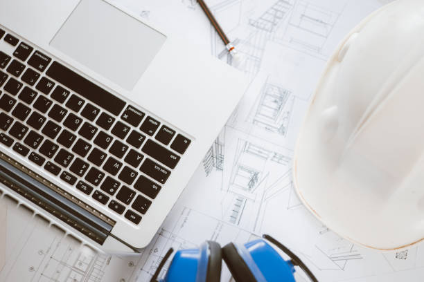 istock Architecture engineer working with blueprints and laptop in office. Inspection in workplace for architectural plan. Construction project. Adviser construction site engineer. 1618015800