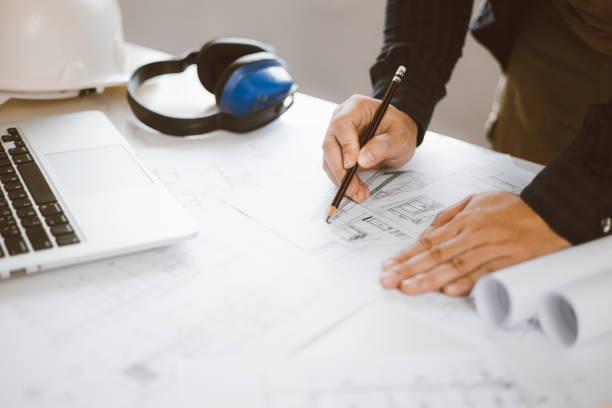 istock Architecture engineer working with blueprints and laptop in office. Inspection in workplace for architectural plan. Construction project. Adviser construction site engineer. 1618016310