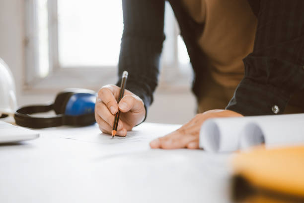 istock Architecture engineer working with blueprints and laptop in office. Inspection in workplace for architectural plan. Construction project. Adviser construction site engineer. 1618016313