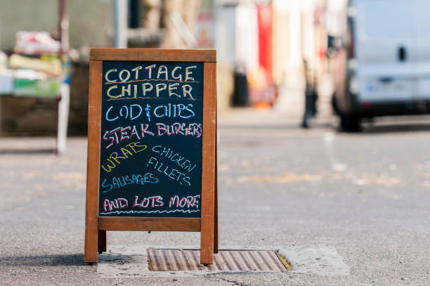 istock Blackboard sign outside a mobile fish and chip van advertising cod, steak burgers, wraps, chicken fillets, sausages etc. 1618053711