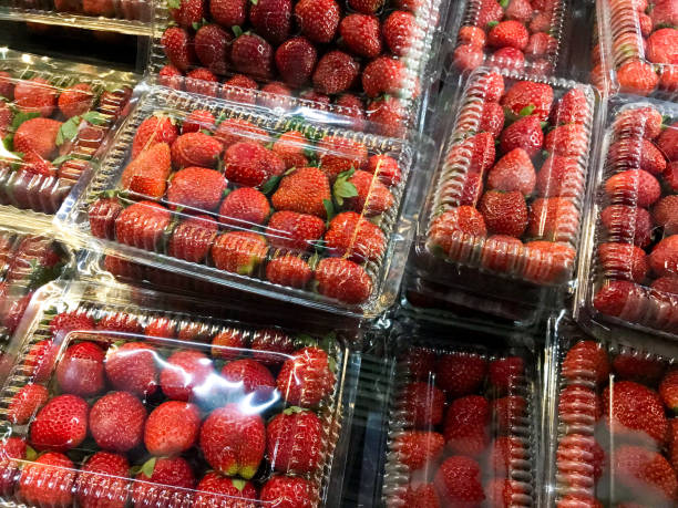 istock Pile of red strawberries in plastic bag or container 1618076512