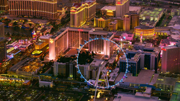 Las Vegas, Nevada/ USA - March 14, 2022: Aerial view of High Roller observation wheel in Las Vegas on The Strip at night.\n\nLas Vegas is the largest city in the US state of Nevada and a world-renowned center for gambling, shopping, fine dining and entertainment. It is mainly famous for its many casinos and the accompanying entertainment-tourism activities, which earned it the nickname of the Entertainment Capital of the World.