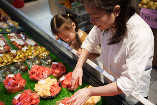 istock mother with daughter buying fruit 1618102210