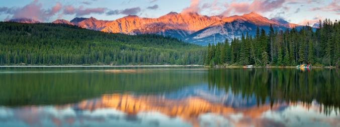 Evening light on the Rocky Mountains, reflected in Pyramid Lake in Jasper National Park, Alberta, Canada.