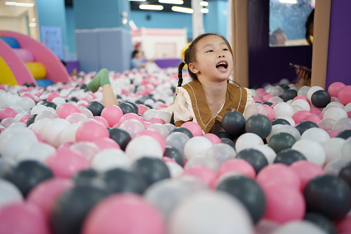 little girl in the sea of ​​balls