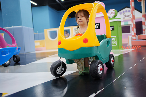 children driving toy cars