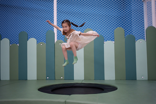 little girl playing on a trampoline