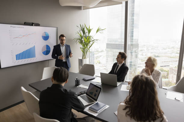 istock Serious young businessman speaking to colleagues at wall display 1618130863