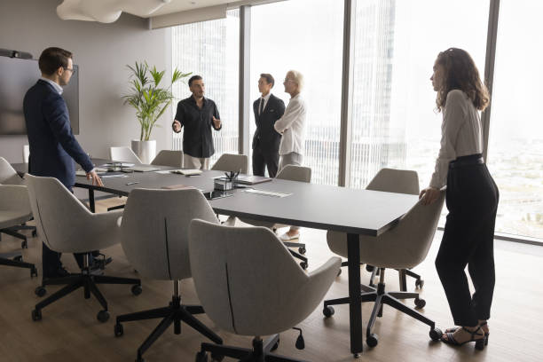 istock Business team standing at large office conference table talking 1618131044