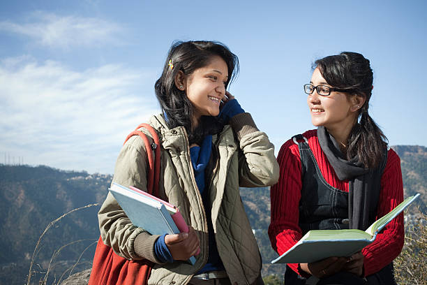 istock Two college students reading book together in mountain area. 161818412
