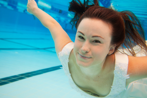 Bride underwater in the style of the Trash the Dress wedding photography trend