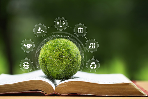 Environment Law. Green globe placed on a law book with icons. law for principles of sustainable environmental conservation.environmental protection and eco-friendly legislation law. International Law