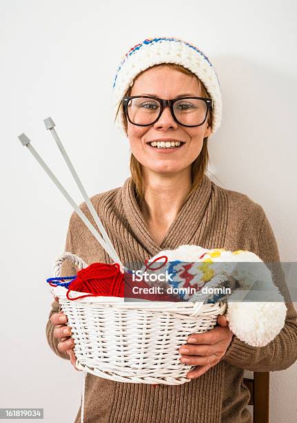 Donna Sorridente Con Gli Occhiali Seduto Su Una Sedia Berretti Invernali Di Maglia - Fotografie stock e altre immagini di Cardigan - Top