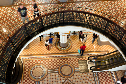 View from second floor down to lobby with people in shopping centre Queen Victoria building Sydney Australia, full frame horizontal composition