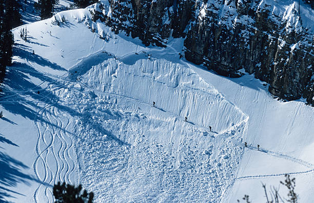 Avalanche Crossing Five backcountry skiers cross a avalanche path while hiking outside of Jackson Hole Resort, Wyoming. avalanche stock pictures, royalty-free photos & images