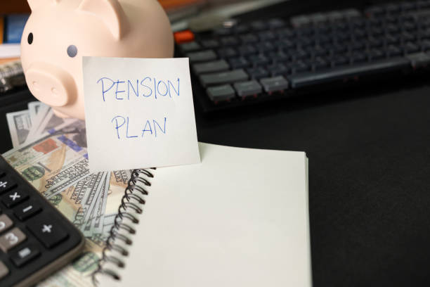 istock Paper note with text PENSION PLAN with stationery on desk. Pension Plan. Retirement concept. Pension calculation concept. copy space for text. Piggy bank. 1618229350