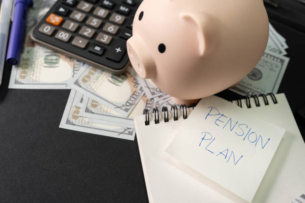 istock Paper note with text PENSION PLAN with stationery on desk. Pension Plan. Retirement concept. Pension calculation concept. copy space for text. Piggy bank. 1618229911
