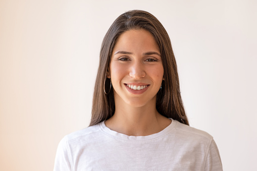Smiling young woman posing isolated on wall background, studio portrait.