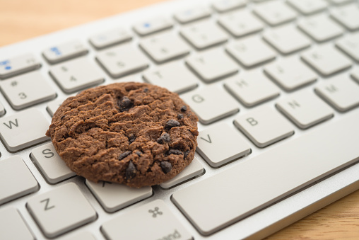 Chocolate chip cookies on keyboard computer background copy space. Cookies website internet homepage policy accpeted or blocks concept.