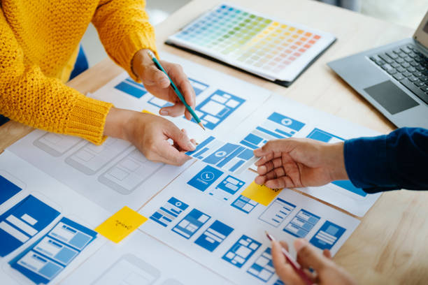 istock Close up view of UI developer team brainstorming on their project with laptop, smartphone and digital tablet. Creative digital development agency. in office 1618259918