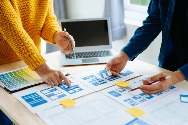 istock Close up view of UI developer team brainstorming on their project with laptop, smartphone and digital tablet. Creative digital development agency. in office 1618259934