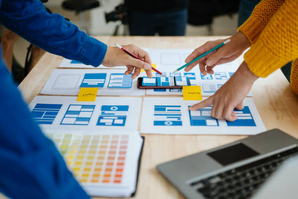 istock Close up view of UI developer team brainstorming on their project with laptop, smartphone and digital tablet. Creative digital development agency. in office 1618259942