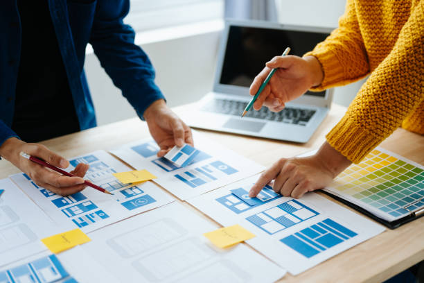 istock Close up view of UI developer team brainstorming on their project with laptop, smartphone and digital tablet. Creative digital development agency. in office 1618259944