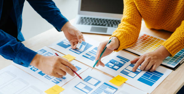 istock Close up view of UI developer team brainstorming on their project with laptop, smartphone and digital tablet. Creative digital development agency. in office 1618259945