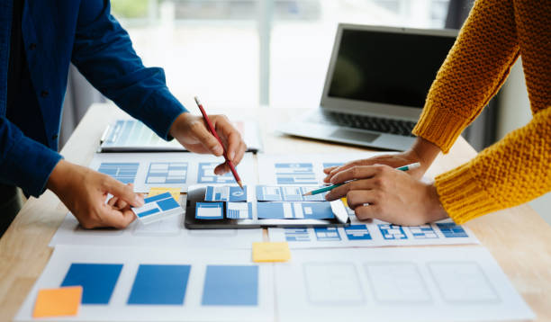 istock Close up view of UI developer team brainstorming on their project with laptop, smartphone and digital tablet. Creative digital development agency. in office 1618259946