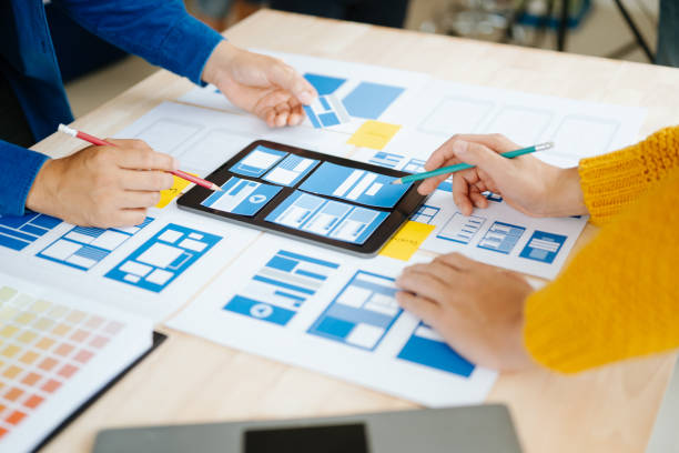 istock Close up view of UI developer team brainstorming on their project with laptop, smartphone and digital tablet. Creative digital development agency. in office 1618259959