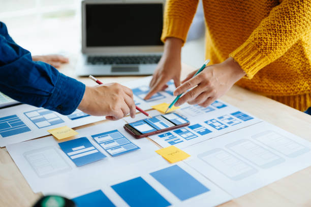 istock Close up view of UI developer team brainstorming on their project with laptop, smartphone and digital tablet. Creative digital development agency. in office 1618259985