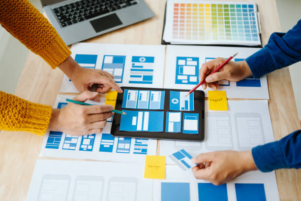 istock Close up view of UI developer team brainstorming on their project with laptop, smartphone and digital tablet. Creative digital development agency. in office 1618260501