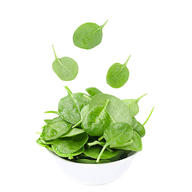 istock white bowl with fresh spinach and falling leaves isolated 161827303